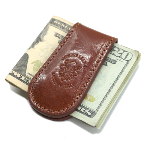 Brown leather money clip on top of U.S. currency with a visible brand logo.